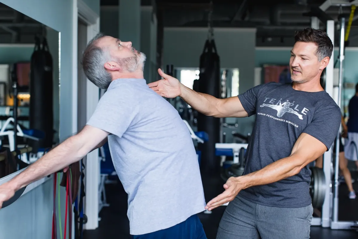 A Temple therapist guiding a client through corrective movement work