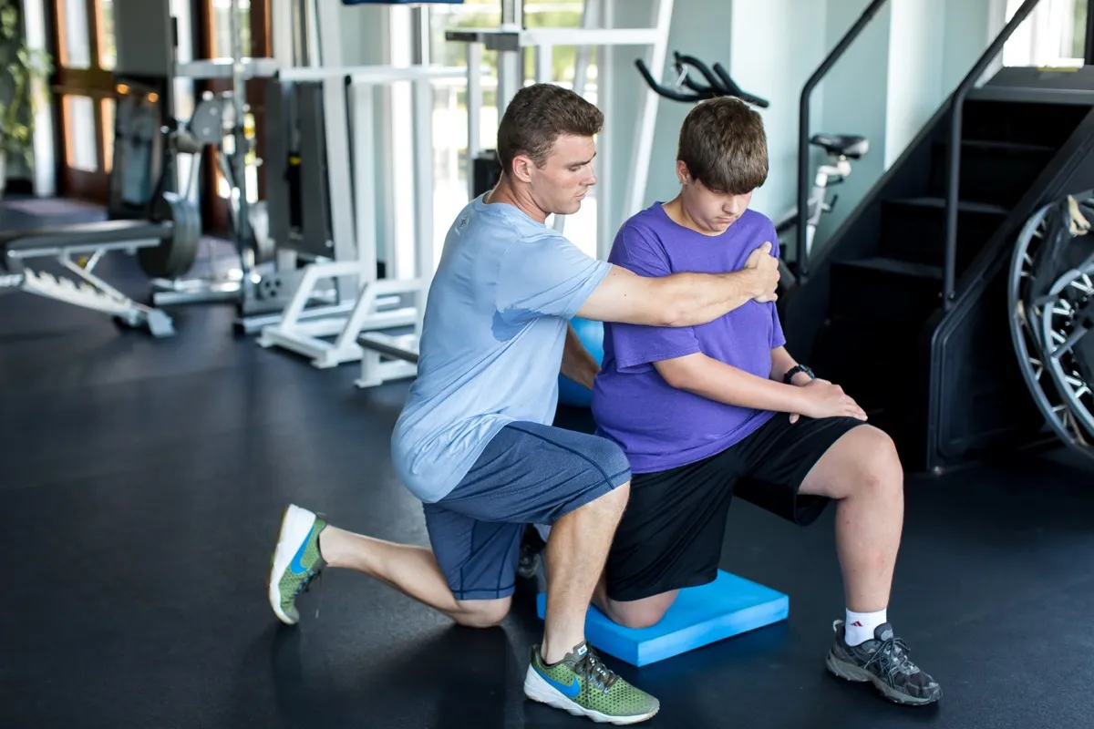 A Temple therapist supporting a client through injury recovery exercises