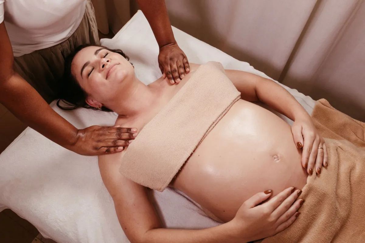A therapist performing prenatal massage on an expectant mother